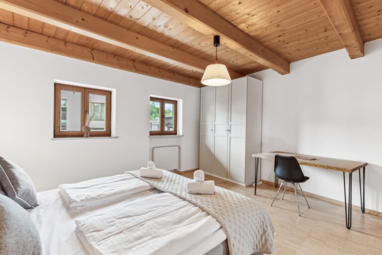 Es befinden sich ein Boxspringbett, ein großzügiger Kleiderschrank als auch ein Arbeitsplatz in diesem Zimmer vor.